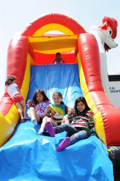 a group of kids on a bounce house slide rental